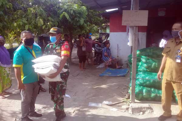 PENYALURAN: Penyaluran Program sembako di e-warong, petugas dari TNI membantu warga membawa beras kepada KPM, Rabu (8/4). sofyan/sumut pos