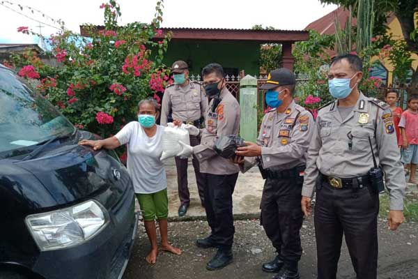 BERIKAN: Kapolsek Medan Area, Kompol Faidir Chan memberikan sembako kepada salah satu warga Jalan Tangguk Bongkar 7, Kecamatan Medan Denai. ist/ SUMUT POS