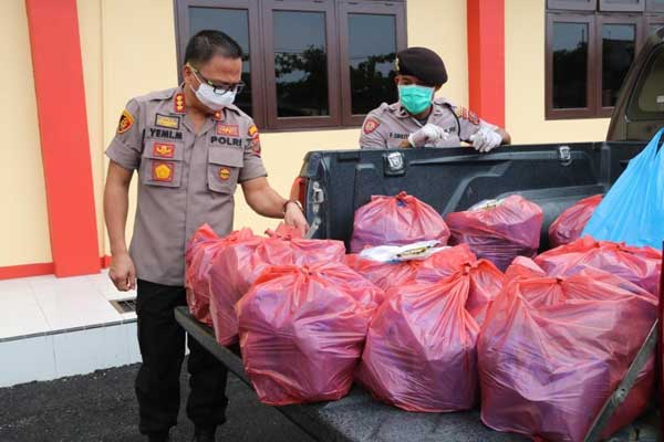 BANTUAN: Kapolres Deliserdang Kapolresta Deliserdang Kombes Pol Yemi Mandagi, SIk memeriksa sejumlah nasi bungkus yang akan dibagikan kepada warga di Halaman Mapolresta Deliserdang, Selasa (7/4).