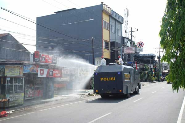 SEPROT: Mobil polisi melakukan penyemprotan disinfektan di Medan,baru- baru ini. Sedangkan Kepling 1 Kota Matsum 4, Medan Area menyemprot ke rumah-warga dan kos-kosan di wilayahnya, Rabu (1/4)