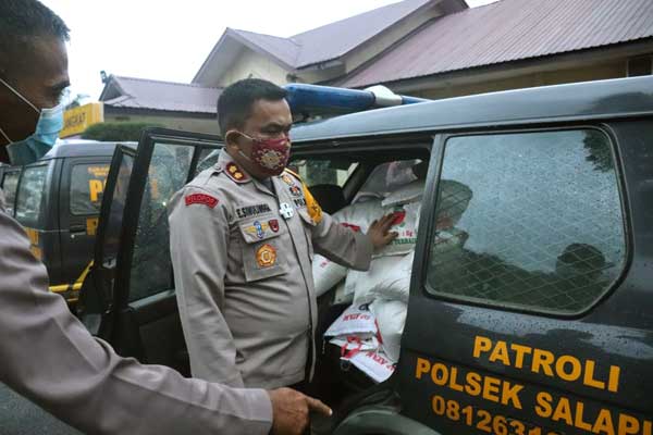 SERAHKAN Kapolres Langkat, AKBP Edi Suranta Sinulingga menyerahkan beras untuk diangkut ke Polsek-polsek.  ILYAS EFFENDY/ SUMUT POS