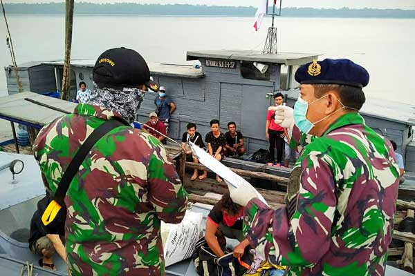 PERIKSA Prajurit TNI memeriksa Kapal Nelayan Jenis Sampan GT-3 tanpa nama dengan 2 ABK memuat 22 orang Pekerja Migran tanpa dokumen resmi dari Malaysia di Tanjung Jumpul, Kabupaten Asahan.