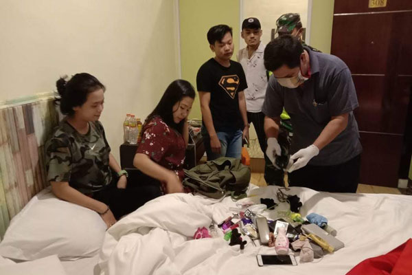 DIPERIKSA: Polisi memperiksa barang bawaan pasangan muda-mudi yang dirazia di Hotel OYO. batara/sumut pos