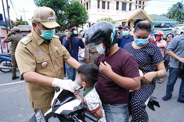 BAGIKAN: Wali Kota Tebingtinggi Umar Zunaidi Hasibuan didampingi Forkompinda membagikan masker geratis kepada masyarakat, pengguna jalan, pedagang dan perbankan di Tebingtinggi. SOPIAN/SUMUT POS