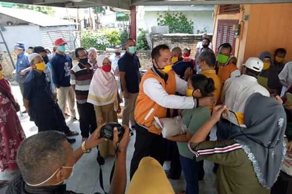 SERAHKAN: Ketua DPC Partai Hanura Kota Tebingtinggi, Ogamota Hulu SH didampingi Kaharuddin Nasution membagikan sembako kepada kader partai.