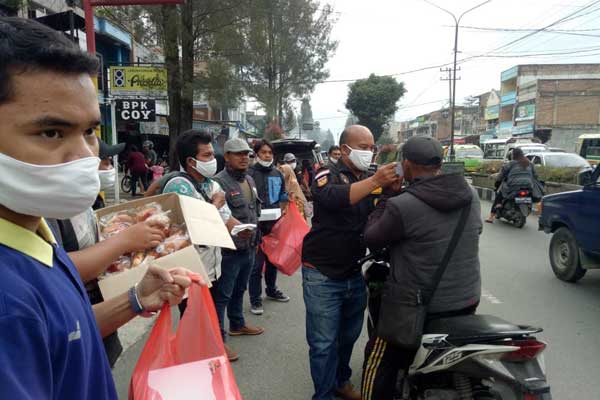 BERBAGI: Jesaya Ginting saat membagikan berkat dan takjil kepada masyarakat.