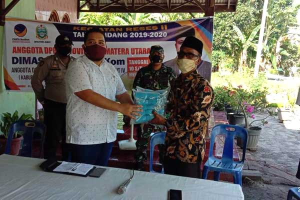 BANTUAN: Anggota DPRD Sumut Dimas Tri Adji SIKom memberikan bantuan secara simbolis kepada Supardi Kades Melati II, Rabu (13/5).