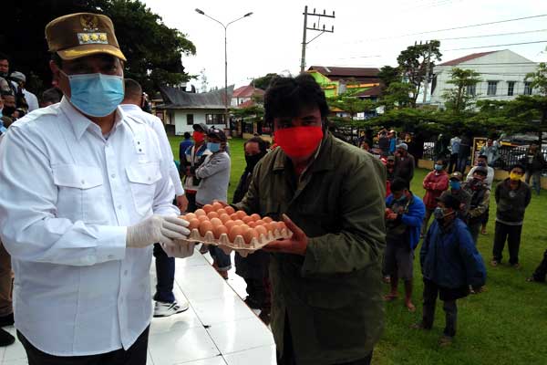 SEMBAKO: Ketua Gugus Tugas Covid-19 yang juga Bupati Dairi, Eddy Keleng Ate Berutu didampingi Sekda, Leonardus Sihotang dan Forkopimda secara simbolis serahkan bantuan sembako kepada koordinator abang becak, Suryanto Manalu, Minggu (17/5).