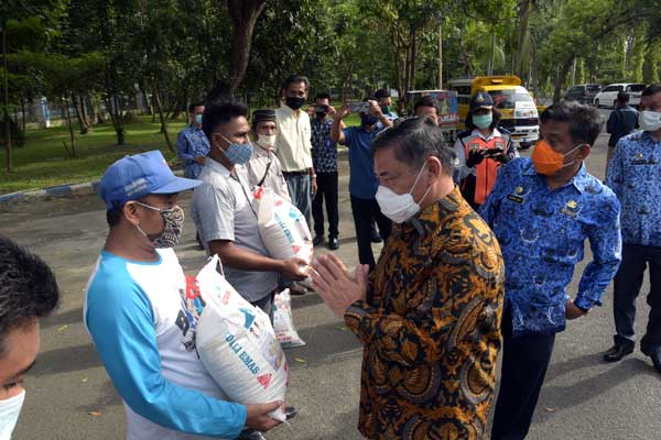 BAGIKAN: Wakil Bupati Deliserdang, HM Ali Yusuf Siregar didampingi Sekdakab sekaligus Ketua KORPRI Deliserdang, Darwin Zein membagikan sembako kepada warga terdampak Covid-19.