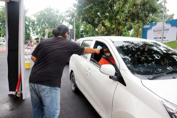 PERIKSA SUHU TUBUH: Seorang pengunjung diperiksa suhu tubuhnya saat memasuki Kampoeng Ramadhan UMKM di PRSU Jalan Gatot Subroto, Medan, Selasa (19/5).