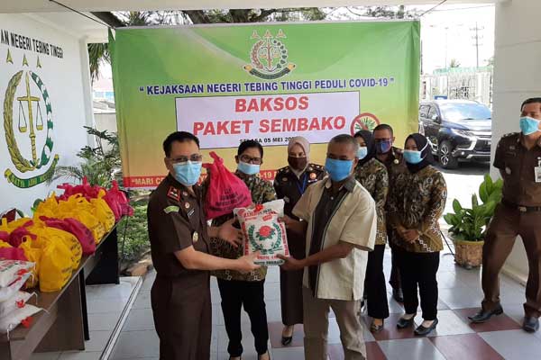 BAGIKAN: Kajari Tebingtinggi Mustaqpirin bersama jajaran membagikan paket sembako kepada masyarakat kurang mampu.