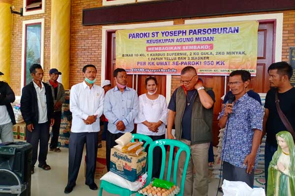 SEMBAKO: Keluarga Tahan Sibarani saat menyerahkan paket sembako di Paroki ST Yoseph Parsoburan. 