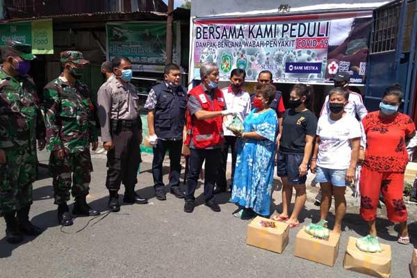 BANTUAN: Ketua Harian PMI Medan, Jhon Ismadi Lubis mewakili Ketua PMI Medan, Musa Rajekshah menyerahkan bantuan secara simbolis kepada warga di Kelurahan Kampung Aur, Medan Maimun.