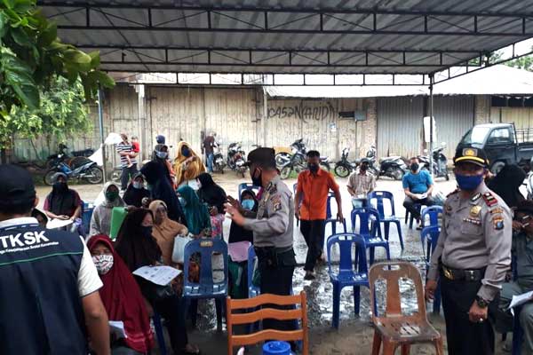 KAWAL: Personel kepolisian mengawal penyaluran BST di Kecamatan Kampung Rakyat, Kabupaten Labusel, Selasa (12/5). Fajar/SUMUT POS