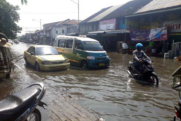BANJIR ROB: Pengendara melintas di genangan air akibat banjir rob di Belawan. Ribuan rumah di 6 Kelurahan di Belawan, terendam banjir, Kamis (7/5).