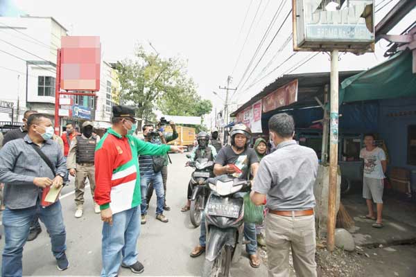 SOSIALISASI Plt Wali Kota Medan mengingatkan pengendara sepeda motor yang melintas di Jalan Bromo untuk mengenakan masker saat melakukan sosialisasi Perwal 11/2020, Sabtu (2/5).