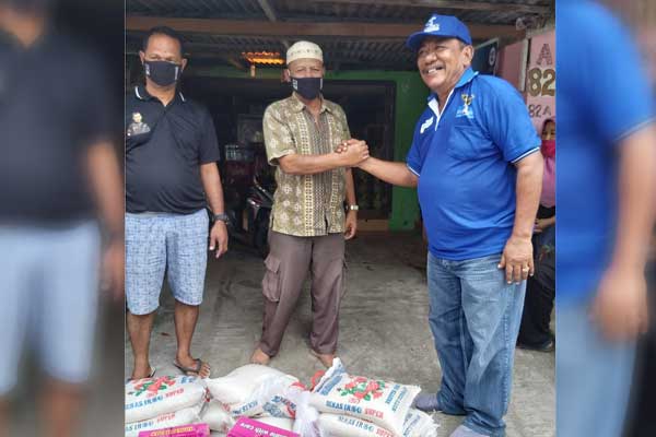 SERAHKAN: Ketua DPC Partai Demokrat Kota Medan Burhanuddin Sitepu menyerahkan paket sembako kepada warga terdampak pandemi Covid-19.