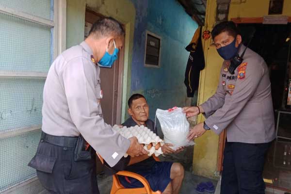 BERIKAN: Kapolsek Medan Area, Kompol Faidir Chan didampingi personel memberikan sembako kepada warga kurang mampu. solideo/ SUMUT POS