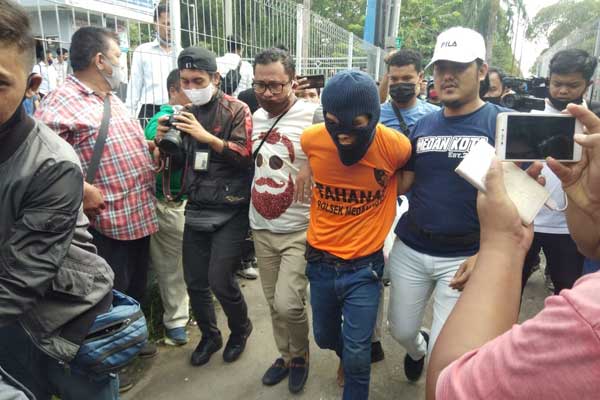 DITANGKAP: Tersangka Ramadsyah pakai tutup kepala digiring Personel Satreskrim Poltabes Medan setelah ditangkap dari tempat persembuyianya di Delitua, Kabupaten Deliserdang. M IDRIS/sumut pos.