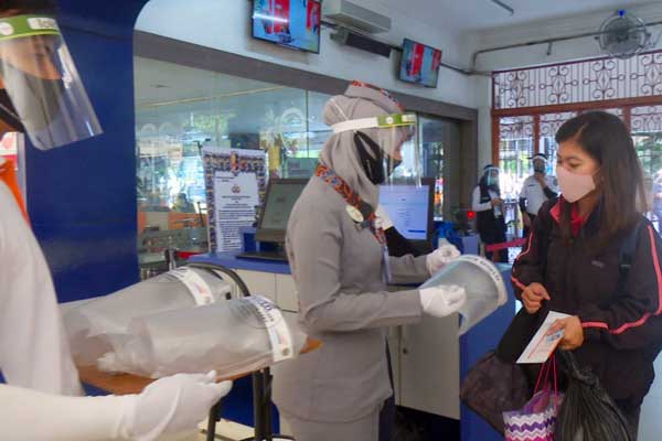 PELAYANAN: Aktivitas pelayanan penumpang kereta api di Stasiun Medan, Rabu (17/6). Penumpang diwajibkan pakai masker dan disediakan face shield.