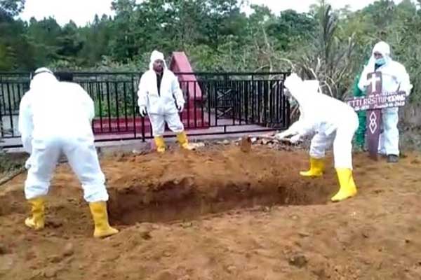 KEBUMIKAN: Kapolsek Lumbanjulu AKP R Sembiring bersama dua anggotanya turut mengebumikan jasad pasien Covid-19 di Desa Motung, Kecamatan Ajibata.