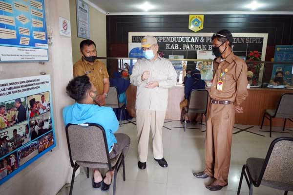 DIALOG: Pj. Bupati Pakpak Bharat, Dr. H. Asren Nasution, MA berdialog dengan masyarakat saat mengurus administrasi kependudukan di Disdukcatpil, Selasa (23/6).Tamba tinendung/sumut pos.