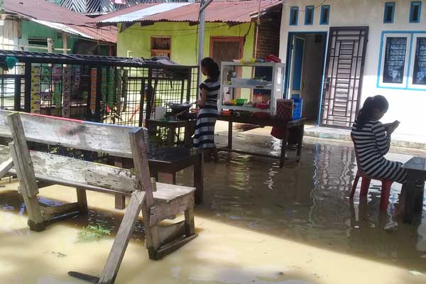 Kampung Semut Kota Tebing tinggi direndam banjir, Kamis (18/6). Meski sedang banjir, warga tetap melakukan aktivitas.