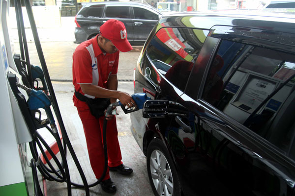 ISI BBM: Seorang karyawan SPBU mengisi bahan bakar minyak ke sebuah mobil di Medan, beberapa waktu lalu.