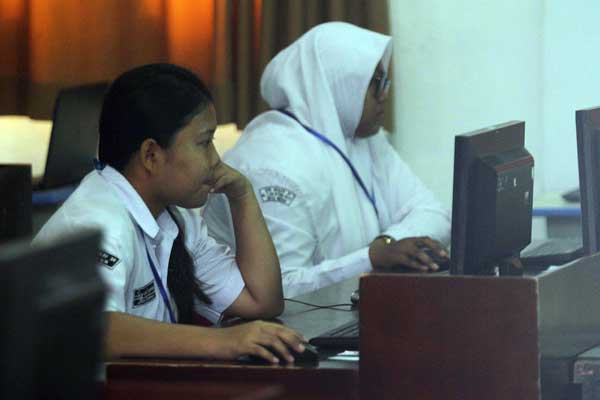 ANTUSIAS: Dua siswi mengikuti pelaksanaan PPDB Online, tahun lalu. Siswa dan siswi di Sumut tetap antusias mengikuti PPDB Online pada tahun ini meski masih dalam situasi pendemi Covid-19.