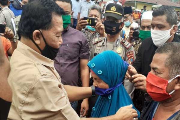 MASKER: Bupati Madina saat menyematkan masker ke warga yang sedang berkunjung ke Pasar Kotanopan, Sabtu (13/6). Pembagian masker ini sebagai wujud untuk menuju New Normal.