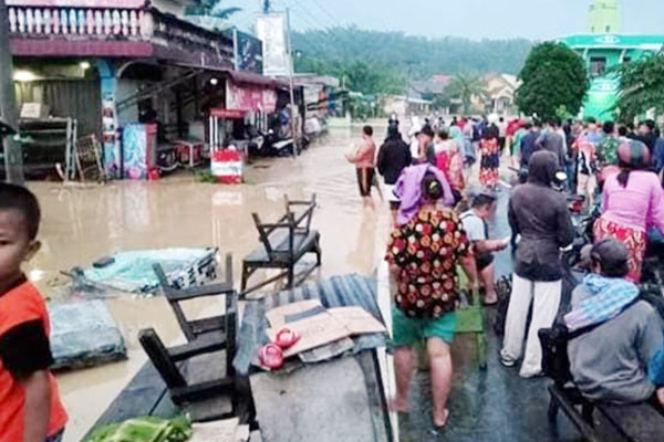 BANJIR: Warga Kelurahan Bandar Durian mengevakuasi harta benda mereka saat dilanda kebanjiran, Jumat (24/7).