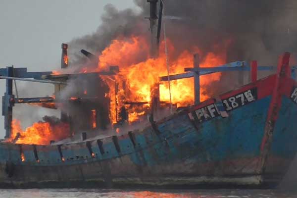 DITENGGELAMKAN: Proses pemusnahan duakapal asing yang dibakar dan kemudian ditarik kapal petugas agar cepat tenggelam. Dua kapal asing itu ditenggelamkan karena mencuri ikan.