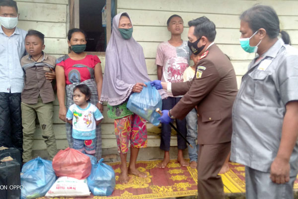 BANTUAN: Kajari Karo Denny Achmad SH, MH menyerahkan bantuan pada Parni, disaksikan Ketua DPC Koswari Karo Gembira Ginting.solideo/ sumut pos.