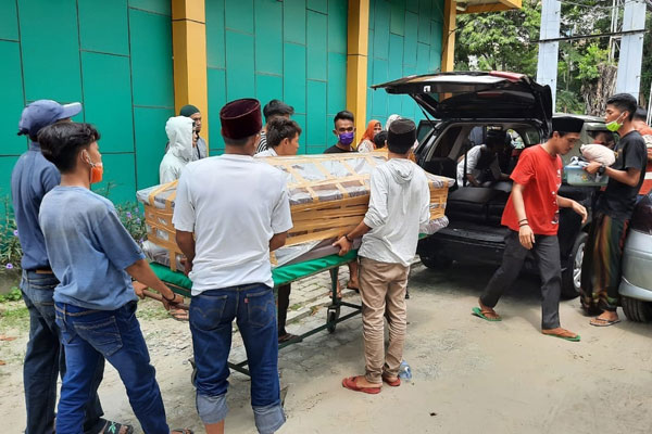 ANGKAT JENAZAH: Sejumlah warga mengangkat jenazah pasien Covid-19 dari RSUD dr Pirngadi Medan untuk dimasukkan ke dalam mobil.