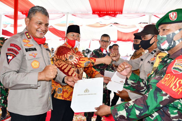 PENGHARGAAN: Kapolda Sumut Irjen Pol Martuani Sormin bersama Bupati Sergai Ir H Soekirman memberikan penghargaan sertifikat kepada Babinsa dan Bhabin Kamtibmas Desa Bingkat (Tangguh), Kamis (9/7).