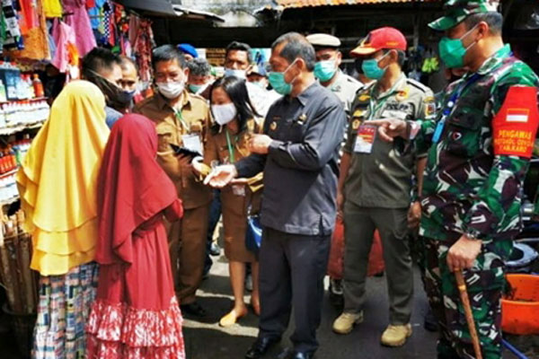 TEGUR:Dandim, Bupati Karo dan Kadis Kesehatan menegur warga yang tak pakai masker di Pusat Pasar Kabanjahe. solideo/ Sumut Pos.