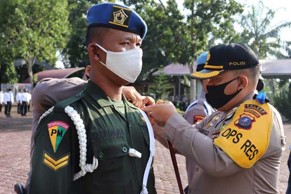 SEMATKAN: Kapolres Langkat AKBP Edi Suranta Sinulingga, sematkan pita kepada salah seorang personel tanda digelarnya Operasi Patuh Toba 2020.