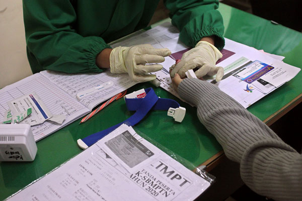 RAPID TEST: Petugas medis sedang mengambil sampel darah pasien untuk rapid test Covid-19 (ilustrasi). Lion Air Group menyediakan fasilitas rapid test murah bagi calon penumpangnya.