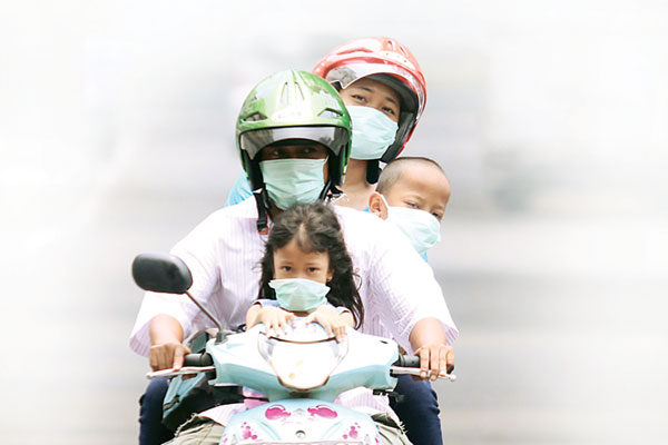 PAKAI MASKER: Pasangan suami istri bersama dua orang anaknya mengenakan masker saat saat mengendarai sepeda motor, beberapa waktu lalu. Menurut penelitian, dengan mengenakan masker, angka penularan Covid-19 bisa ditekan hingga 5 persen.