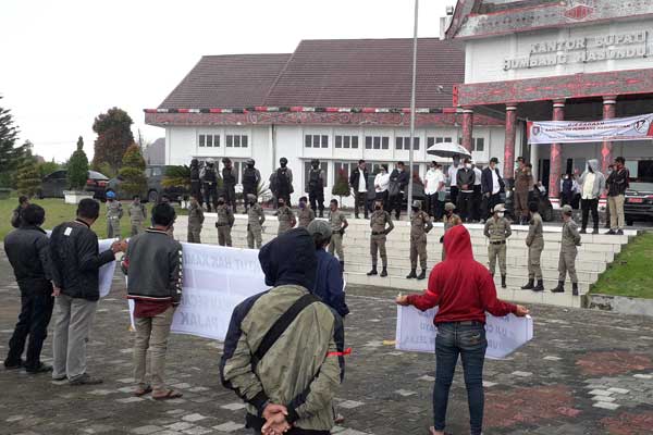 AKSI: Puluhan pedagang didampingi mahasiswa, tampak di bawah guyuran hujan menyampaikan tuntutannya di depan kantor Bupati Humbang Hasundutan.