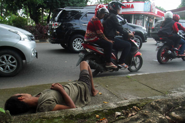 prans/sumu tpos GEPENG: Seorang gelandangan pengemis (gepeng) tidur di atas trotoar jalan.