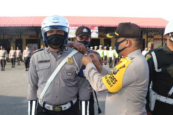 SEMATKAN : Kapolres TebingtinggI AKBP James P Hutagaol menyematkan tanda pita kepada personel tanda dimulainya ops patuh toba.