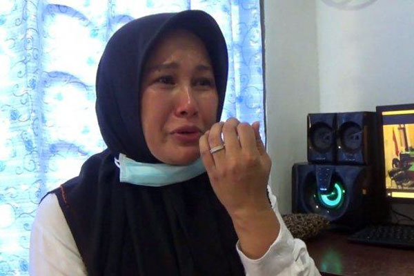 MENANGIS: Zuraida Hanum, istri hakim PN Medan Jamaluddin menangis usai mengikuti persidangan secara online.
