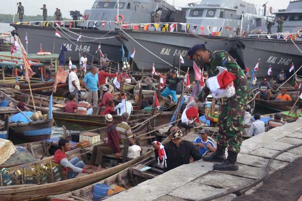 Bagikan Bendera: Komandan Lantamal I, Brigjen TNI (Mar), I Made Wahyu Santioso, membagikan bendera kepada para nelayan di Belawan.