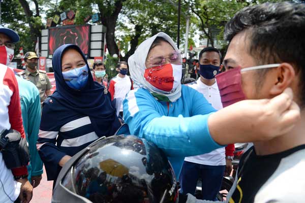 PAKAIKAN MASKER: Ketua TP PKK Sumut Nawal Edy Rahmayadi, memakaikan masker kepada salah seorang pengendara motor di acara Gerakan Bersama Pakai Masker atau Gebrak Masker serentak se-Indonesia, Senin (17/8).istimewa/sumu tpos.