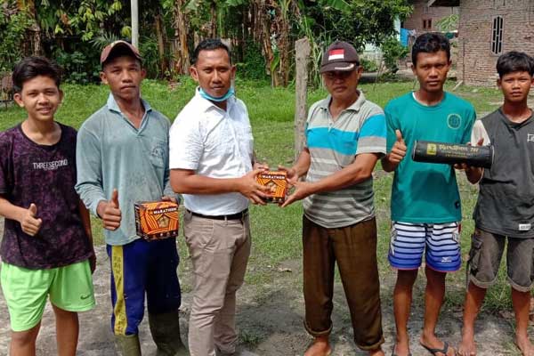 BANTUAN: Tokoh pemuda Desa Jambur Pulau (Jampul) Iwan Sawit berikan bantuan perlengkapan sepak takraw, Minggu (2/8).