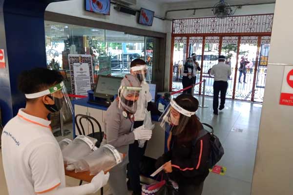 PERIKSA: Petugas KA memeriksa suhu tubuh calon penumpang yang akan naik ke atas kereta api.