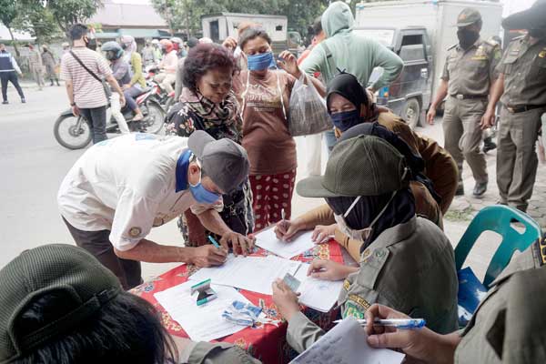 PENEGAKAN PERWAL: Petugas Satpol PP Medan menahan KTP milik sejumlah pelanggar protokol kesehatan, dalam razia masker di sejumlah titik di Kota Medan, Selasa (25/8).