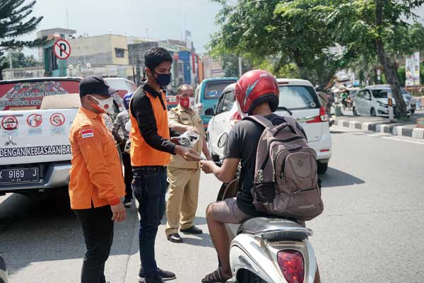 BAGIKAN MASKER: Tim Monitoring Penegakan Disiplin Protokol Kesehatan Covid-19 Mebidang membagikan masker sekaligus melaksanakan sosialisasi dan edukasi kepada masyarakat di Medan. Selasa, (25/8).