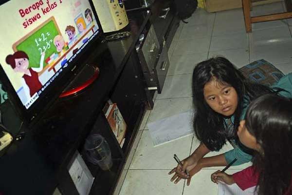 BELAJAR: Anak-anak sedang belajar dari televisi di rumah beberapa waktu lalu.